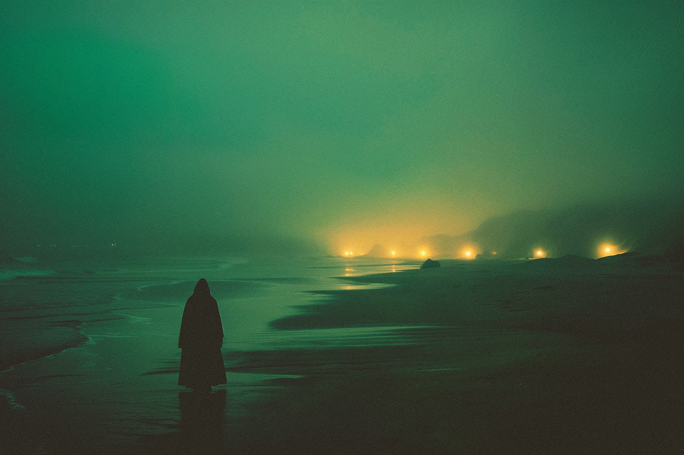 A lone hooded person walking on an empty beach at the sea. The evening light conveys a quiet, magical mood. An ethereal, minimalist new media AI artwork on the beauty and magic of loneliness, inspired by the cinematic look of Blade Runner 2049. | Wall Art